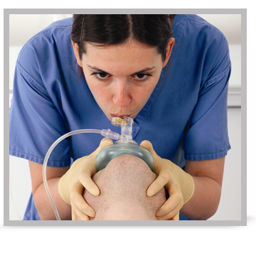 A female clinician performing mouth to mask ventilation.