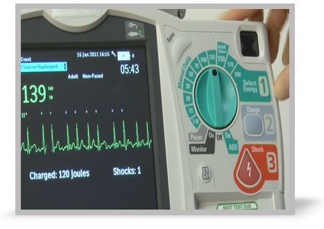 A clinician pressing the shock button of a defibrillator. 